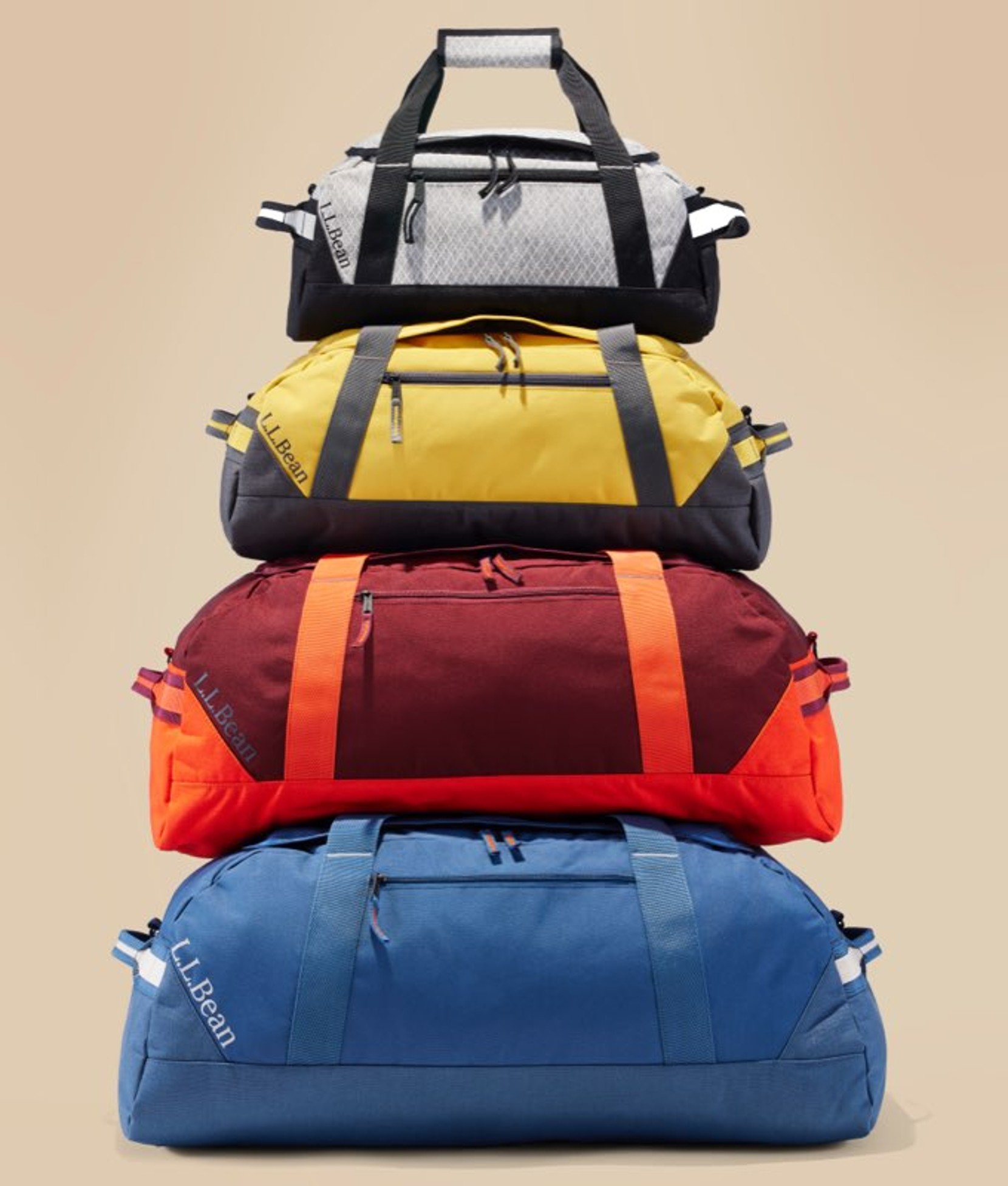 Stack of colorful duffel bags in yellow, blue, red, and black.