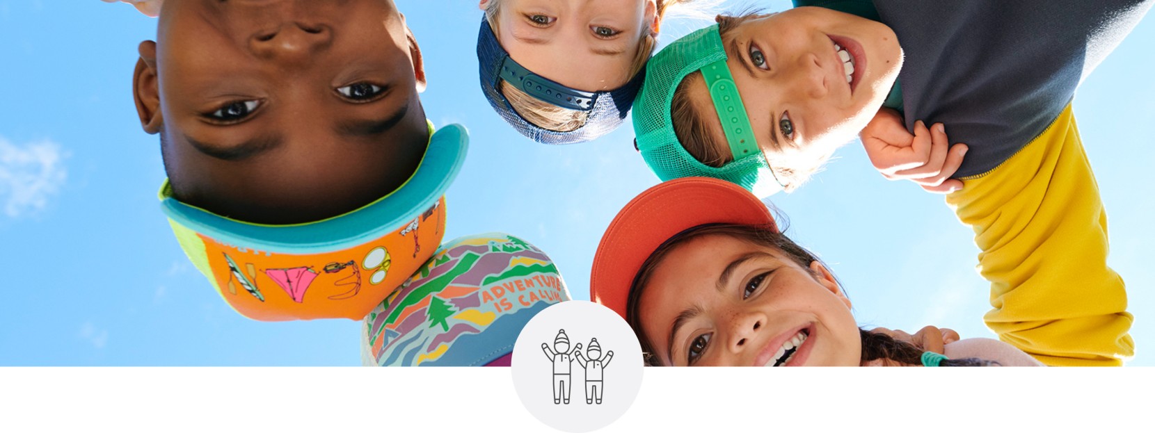 Close-up of 6 happy kids in a circle looking down on the camera.