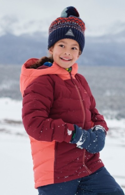 Waist up shot of child outside wearing insulated jacket and hat.