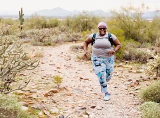 Mirna Valerio trail running in a desert.