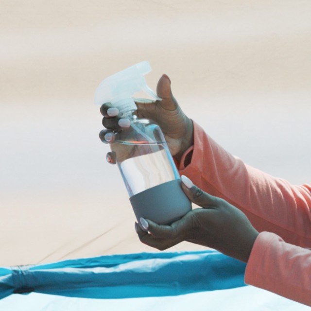 A close-up of a spray bottle in Stephanie's hands.