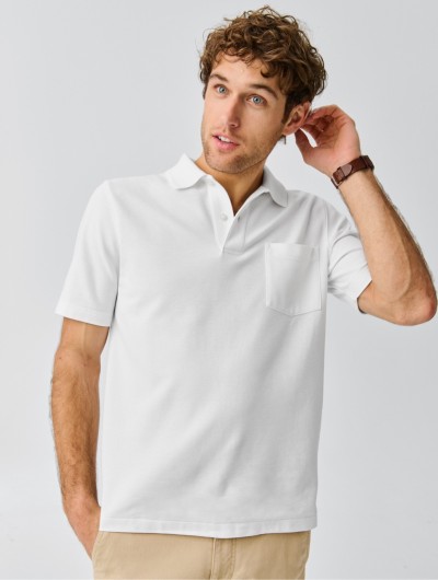 A thigh-up shot of a man wearing a white polo shirt.