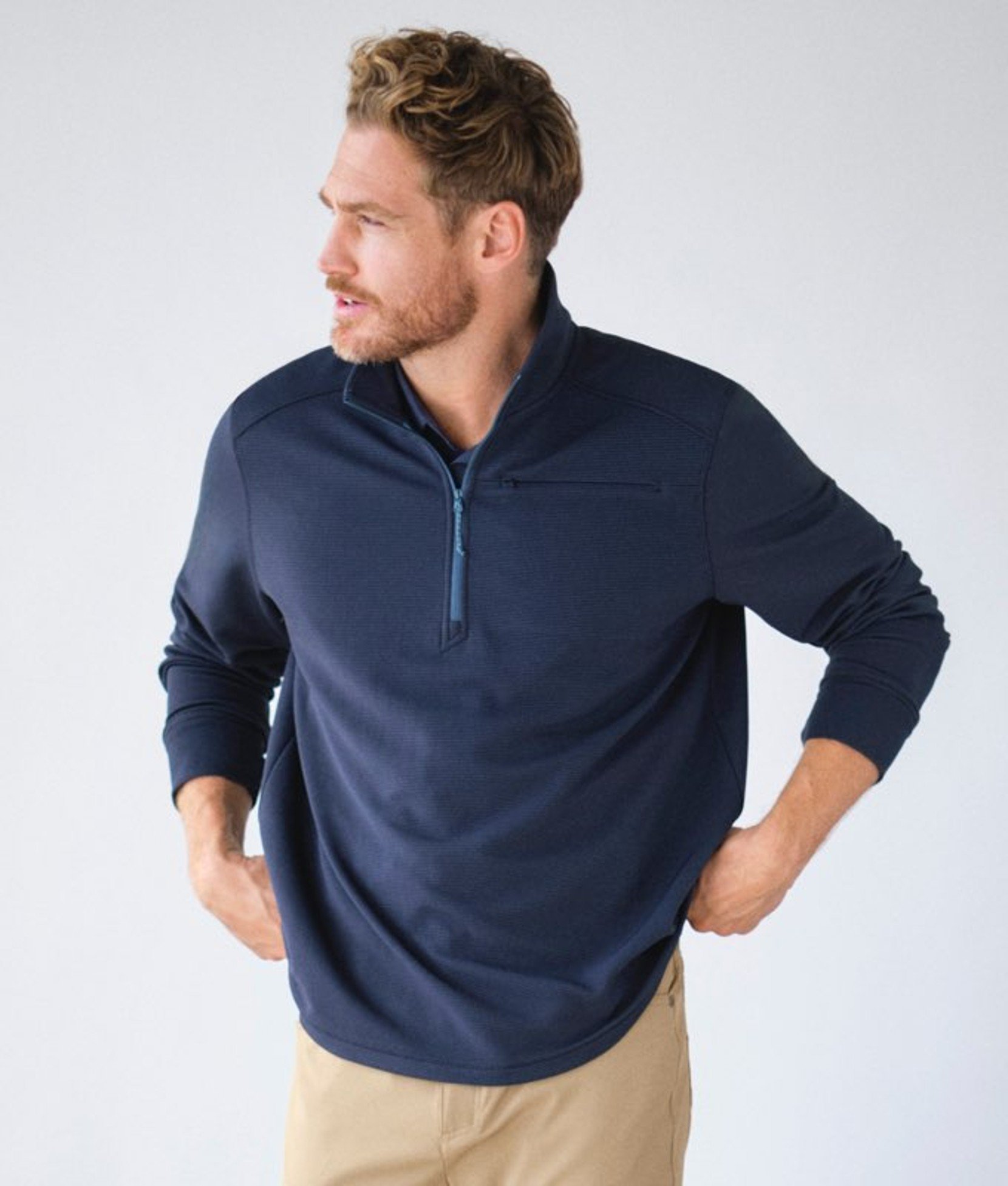 Navy men’s quarterâ€‘zip activewear top worn by a model. 