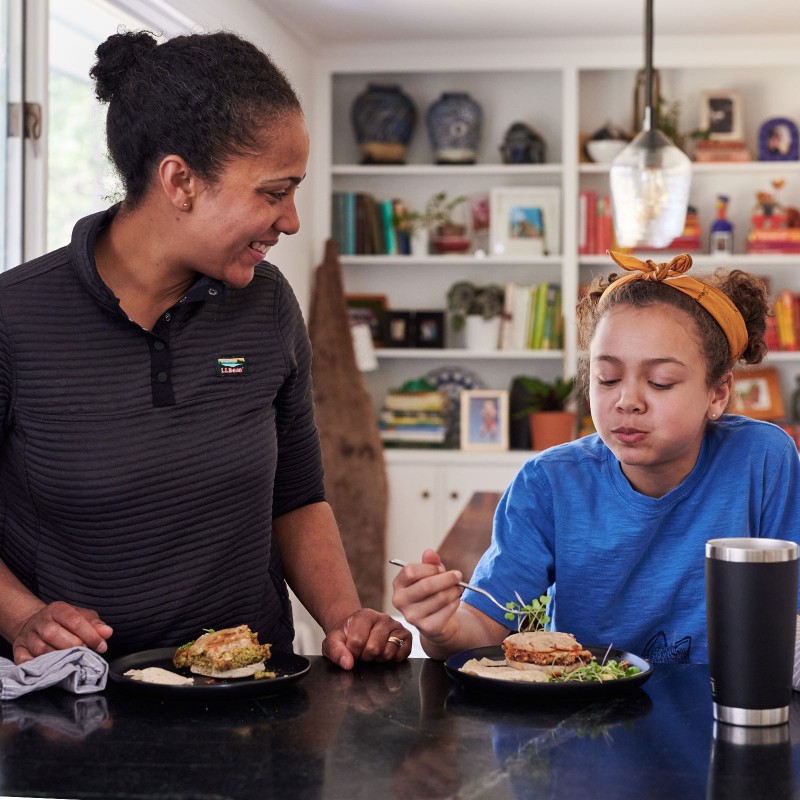 Mom and daughter having a camp meal in the kitchen.