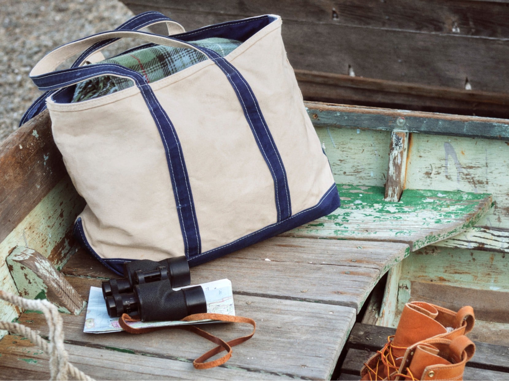 Canvas Boat & Tote bag and sunglasses resting on a weathered wooden boat bench.