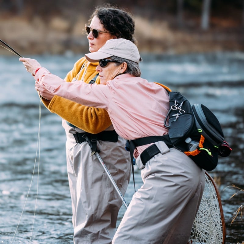 Julie M. being coached by her fly-fishing instructor, Sue.