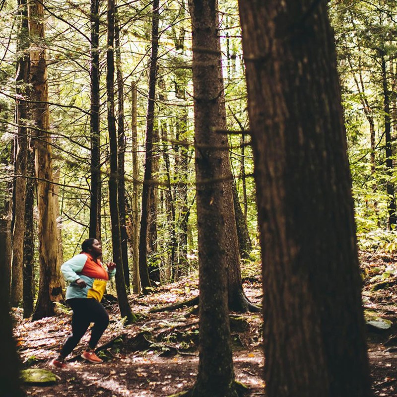 L.L.Bean Ambassador Mirna Valerio running on a trail in the woods.