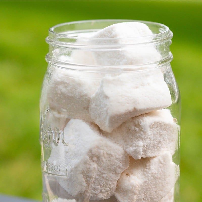 A jar of powder sugar dusted marshmallow.