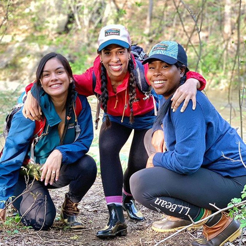 Three hiking friends posing for the camera outside.