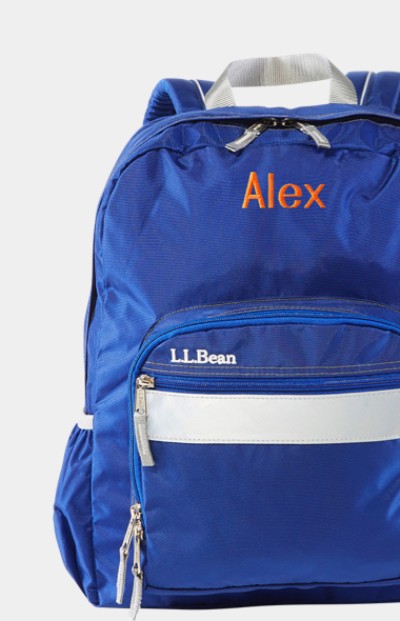 Close-up of a blue school backpack with "Alex" monogrammed on it.