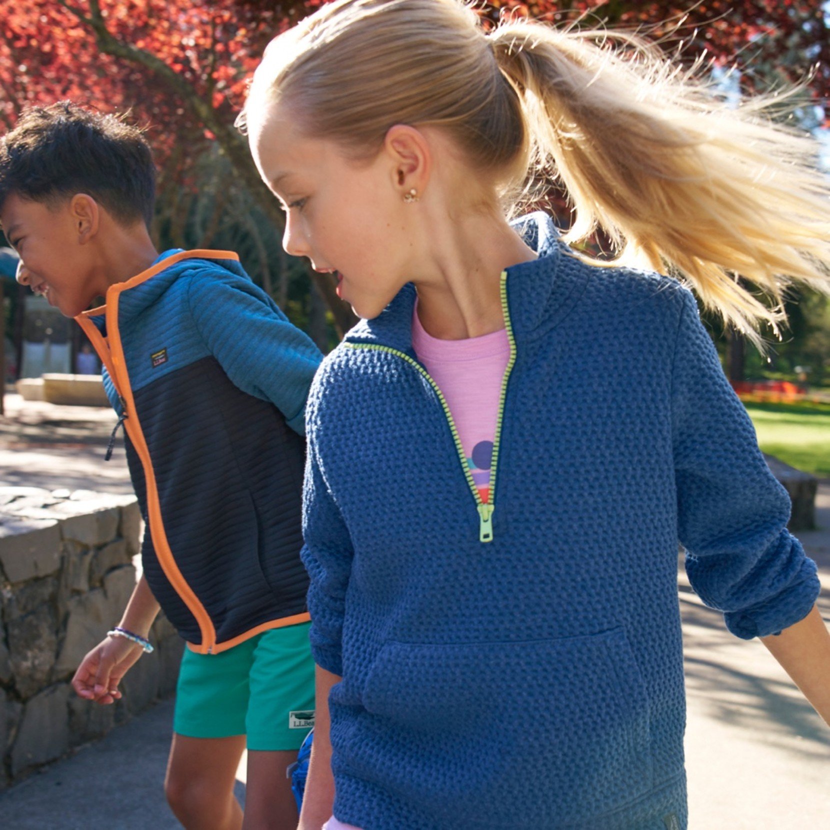 2 kids in L. L. Bean clothing playing outside.