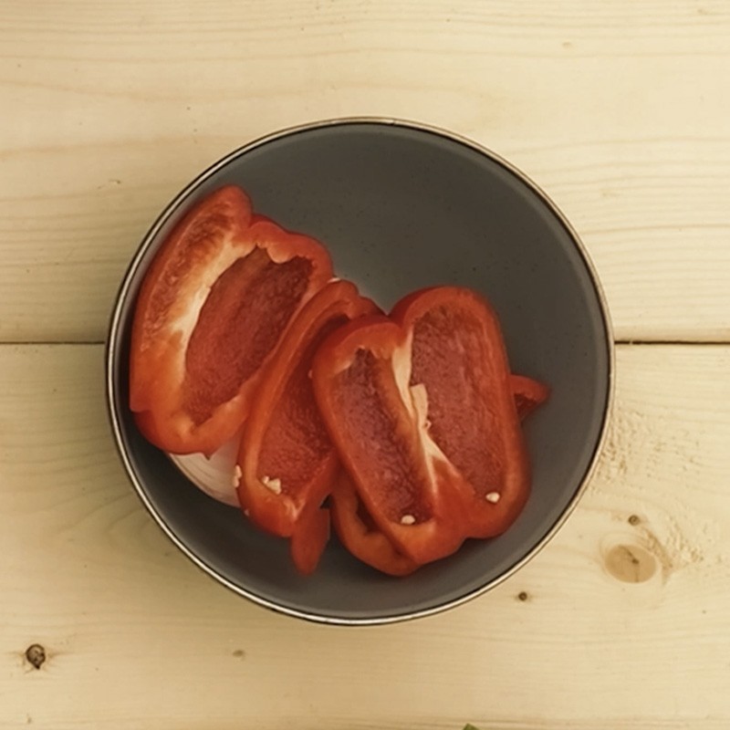 A camp bowl with a cut red pepper in it.