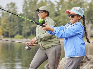 A father teaching a son how to fly fish.