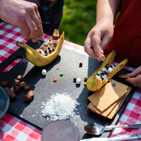 Close-up of adult and child building banana boats