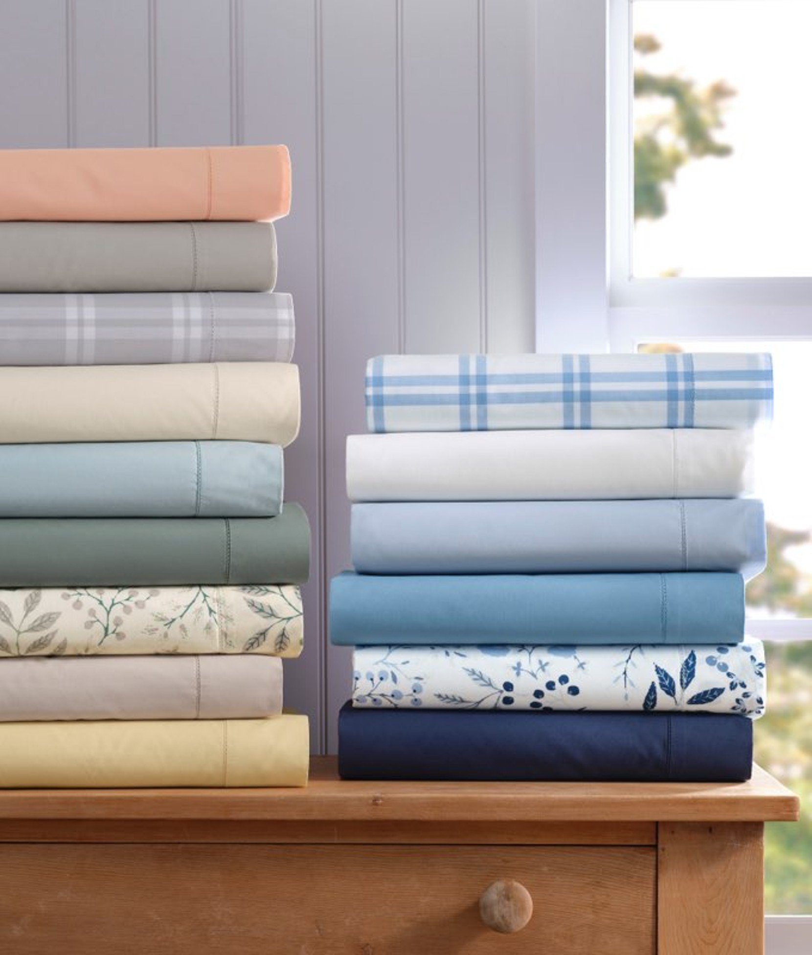 Stack of neatly folded home textiles in soft colors.