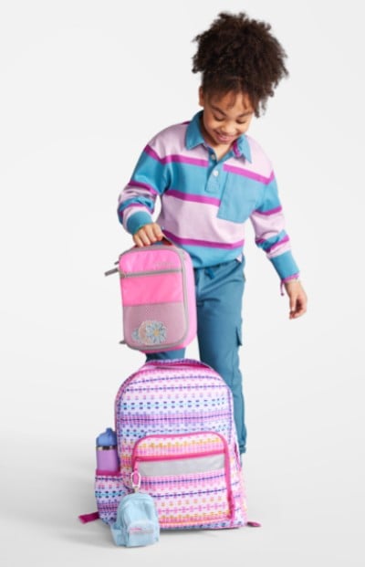 Young girl with coordinating school backpack and lunchbox.